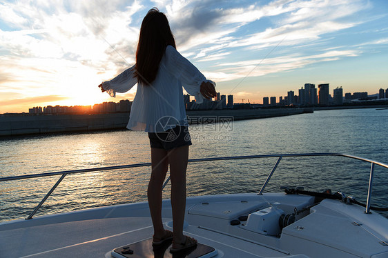 夕阳下在海边的青年女人图片