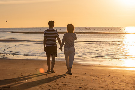 快乐的老年夫妇在海边散步图片