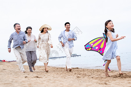 快乐的一家人在海滩上放风筝图片