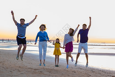 沙滩跳跃女孩在海边欢呼跳跃的幸福家庭背景