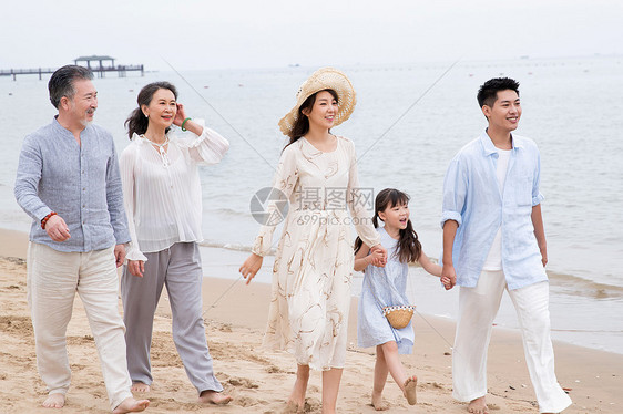 快乐的一家人在海滩上散步图片