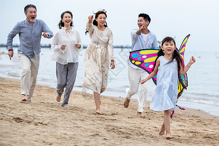 沙滩上的一家人快乐的一家人在海滩上放风筝背景