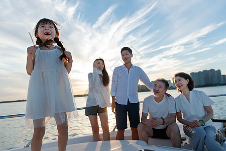 渡船上一家人夕阳下在游艇上的快乐一家人背景
