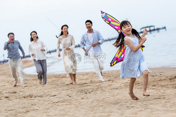 快乐的一家人在海滩上放风筝图片