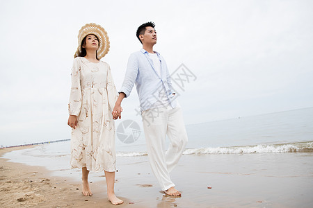 浪漫的青年夫妇在海边散步图片