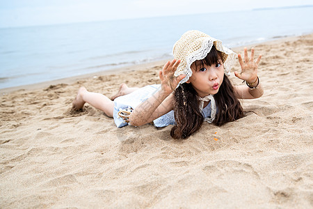 趴在海滩上玩耍的小女孩图片