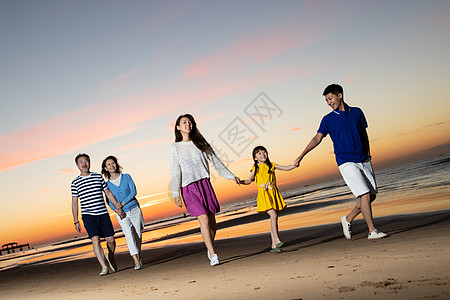 海滩晚霞夕阳下在海边散步的幸福家庭背景