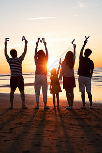 海滩晚霞在海边度假的快乐家庭背景