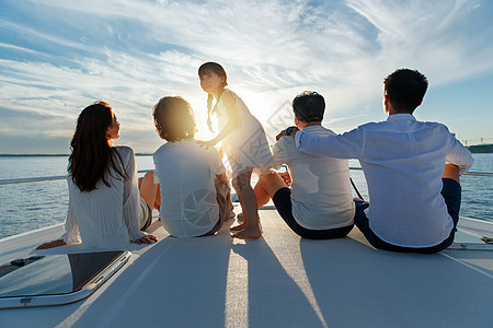 夕阳下坐在游艇上的快乐一家人图片
