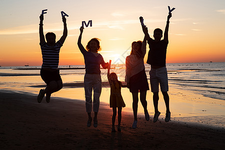 夕阳下的女性背影在海边度假的快乐家庭背景