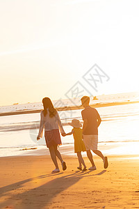 海边一家人夕阳下一家三口在海边玩耍背景