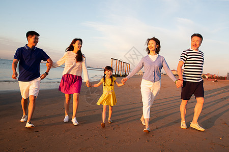 海边一家人夕阳下在海边散步的幸福家庭背景