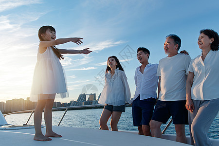 夕阳下在游艇上的快乐一家人图片