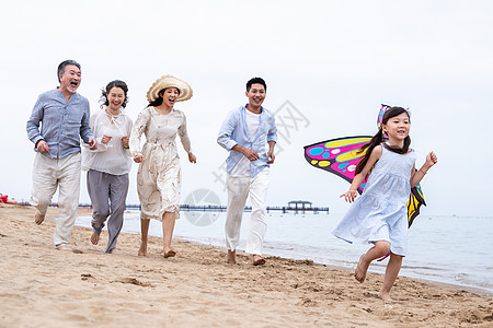 沙滩上的一家人快乐的一家人在海滩上放风筝背景