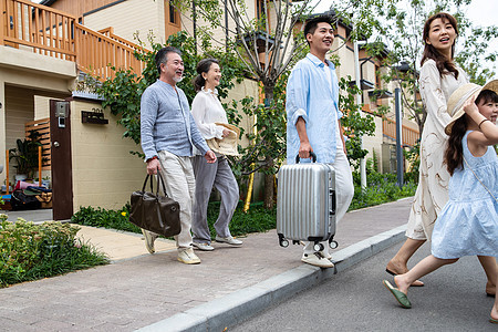 快乐家庭拿着行李箱旅行度假图片