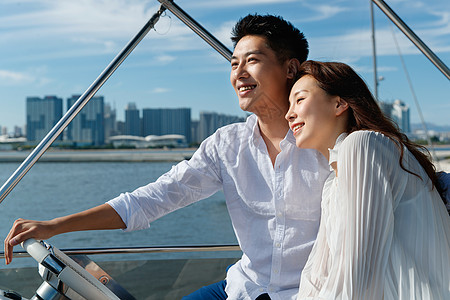 浪漫的青年夫妇驾驶游艇出海图片