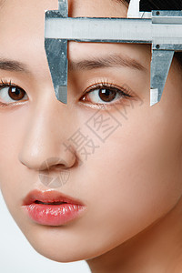 护肤流程整形医生用卡尺测量青年女人面部背景