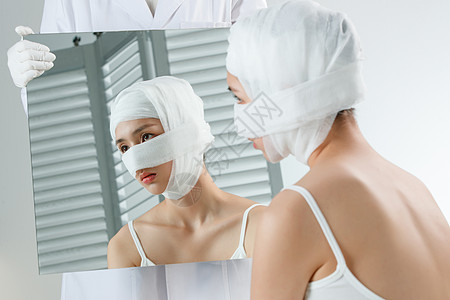 手术包做面部整形的青年女人照镜子背景