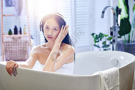 浴缸内听音乐的年轻女孩图片