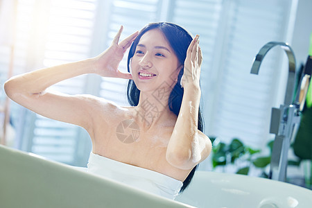 浴缸内听音乐的年轻女孩图片