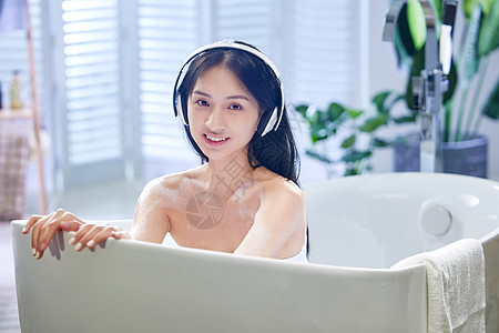 浴室水龙头】浴缸内听音乐的年轻女孩背景