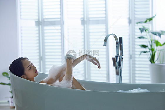 漂亮的年轻女人洗泡泡浴图片