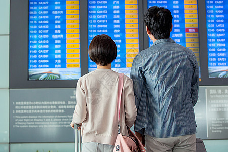 青年情侣在机场候机厅看航班表图片