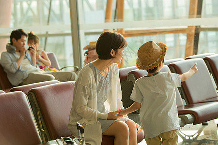 年轻妈妈和儿子在机场候机厅图片
