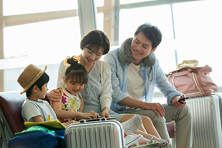 快乐家庭在机场候机厅里看平板电脑图片