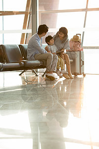 一家三口坐在机场候机大厅图片
