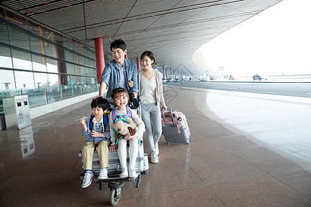 欢乐家庭在机场推着行李图片
