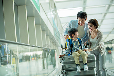 一家三口在机场推着行李图片