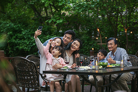 快乐大家庭在庭院里用餐图片