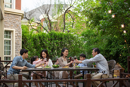 快乐大家庭在庭院里用餐图片