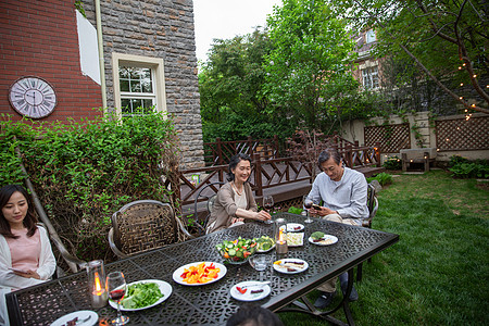 快乐家庭在庭院里用餐图片