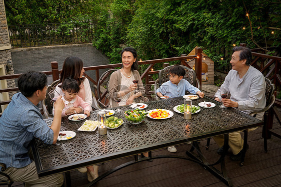 快乐大家庭在庭院里用餐图片