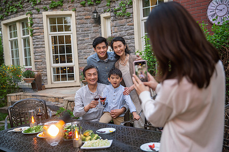 红酒生活快乐大家庭在庭院里用餐背景