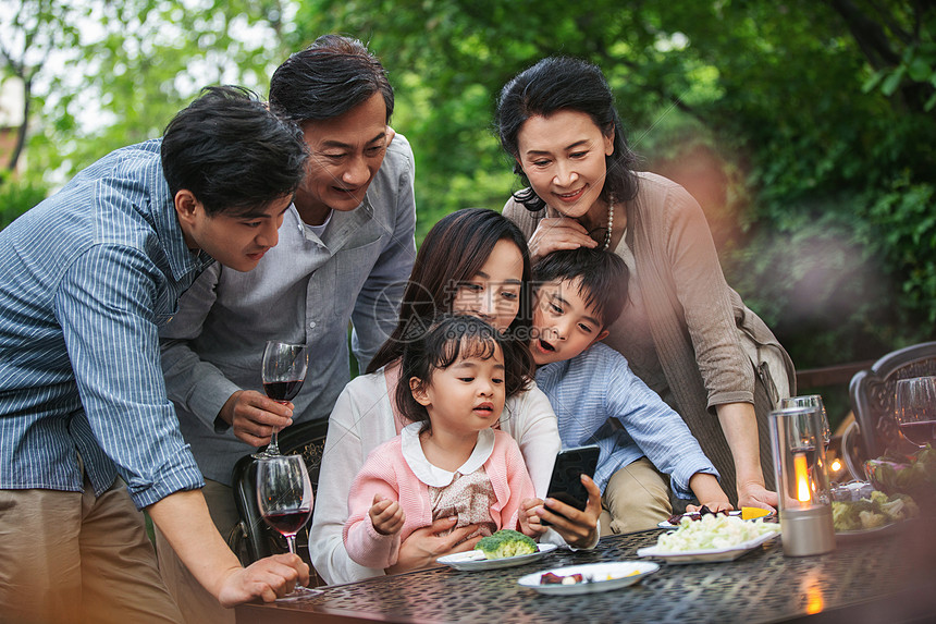 快乐大家庭在庭院里用餐图片