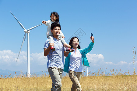 风力发电风车快乐家庭在户外郊游背景