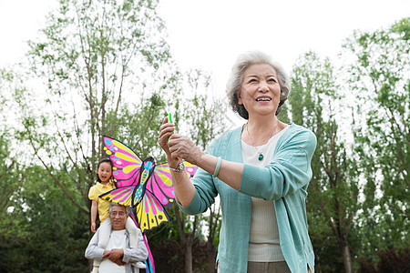 老年夫妇带着孙女在公园里放风筝图片