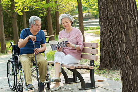 老年夫妇坐在公园里看书图片