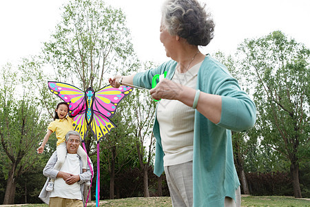 老年夫妇带着孙女在公园里放风筝图片