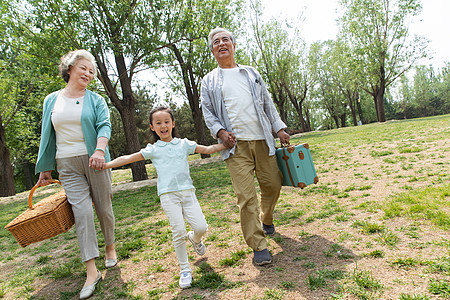 老年夫妇带着孙女在公园里郊游图片