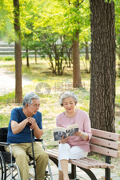 老年夫妇坐在公园里看书图片