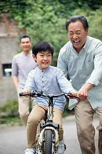 爷爷协助孙子骑自行车图片