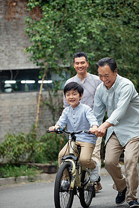 爷爷协助孙子骑自行车图片