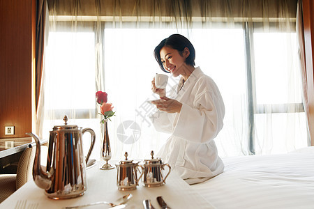 年轻女人在酒店房间里喝咖啡图片