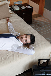 青年男士躺在酒店床上图片