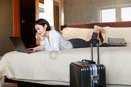 年轻女人趴在床上用电脑图片