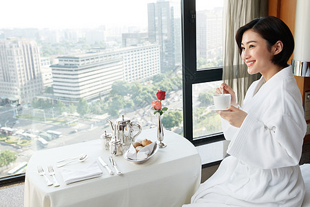 年轻女人在酒店房间里喝咖啡图片